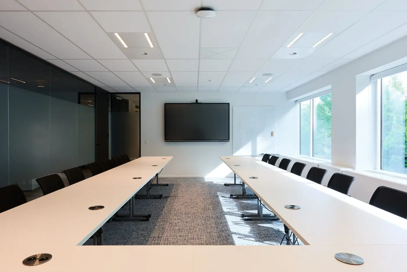 Poste de travail et plantes vertes dans un bureau aménagé à Diegem · aménagement de bureaux